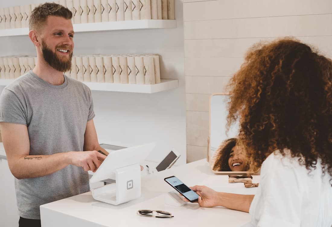 A local shop owner serving a customer at the counter