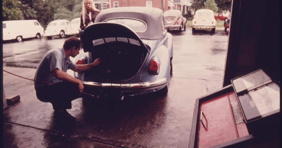 A mechanic checks a car's rear engine at a service station, the everyday work behind auto repair shop citations.
