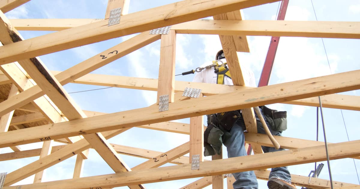 A worker framing a roof at height on a residential build, the kind of job citation building for contractors backs up.