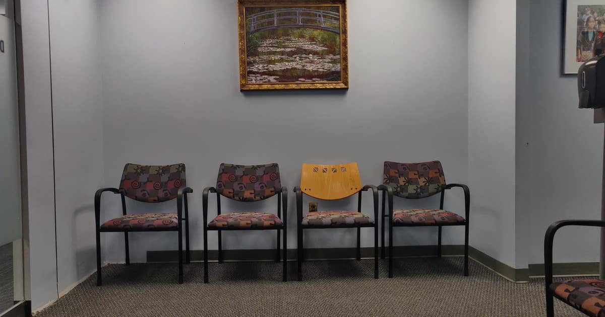 An empty medical waiting room with chairs along the wall, the office citation building for doctors helps patients find.