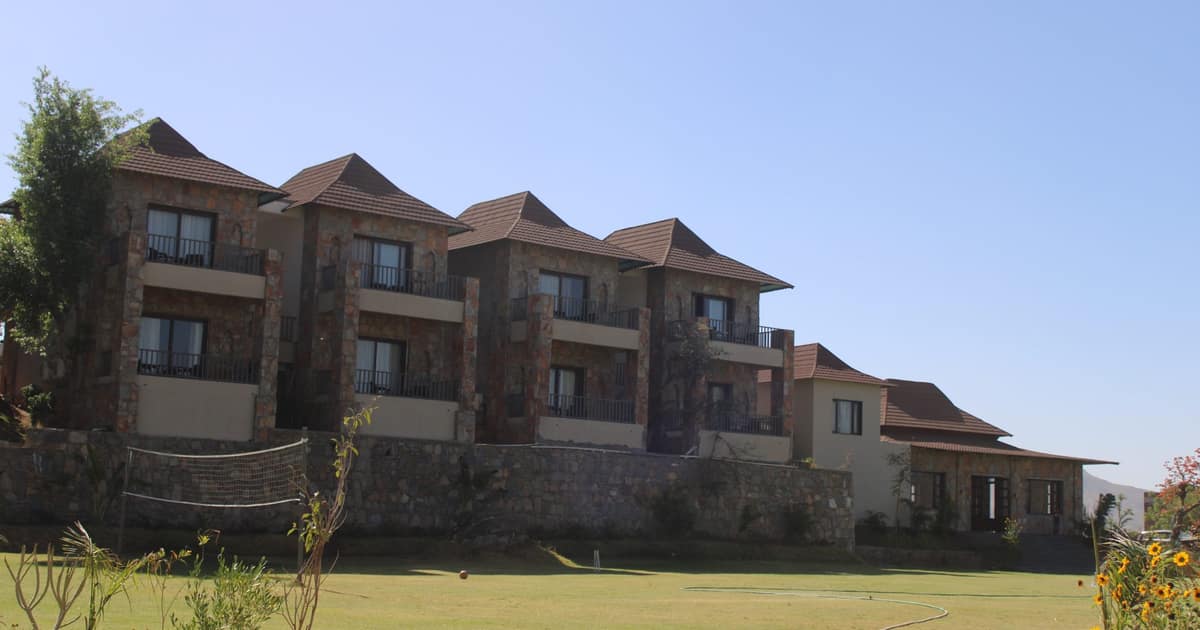A stone residential property with balconies and a manicured lawn, the listing citations for real estate agents support.