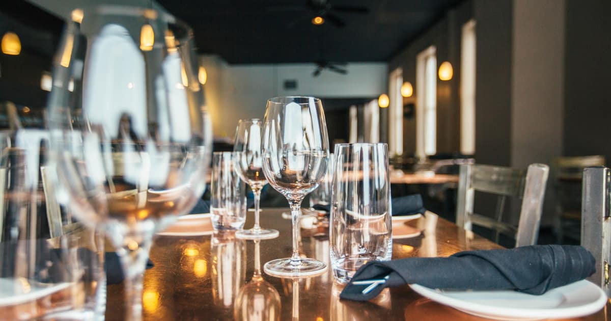 A candlelit restaurant table with wine glasses, the dining room citation building for restaurants points diners to.