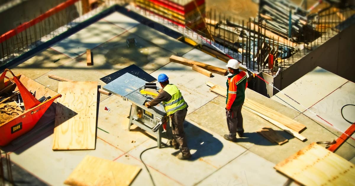 Workers cut lumber on an active job site, the kind of visible work local SEO for home builders needs to prove online.