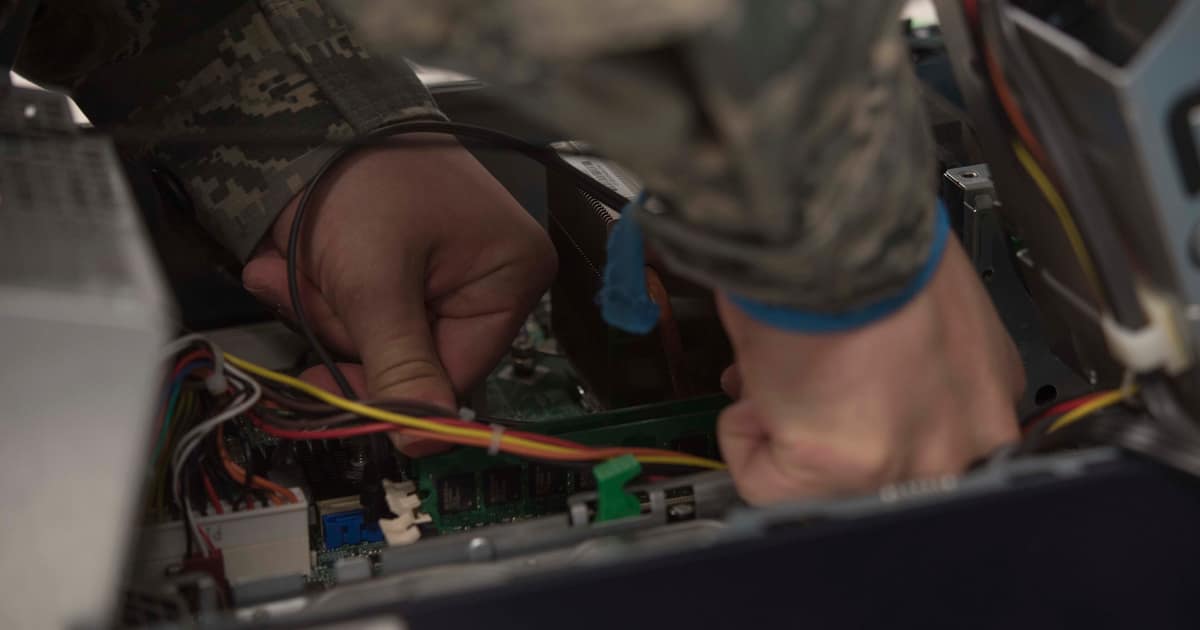 Hands repairing components inside an open PC case, the hands-on work local SEO for IT services and MSPs must prove is local.